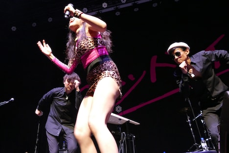 腰を振りまくる益子寺かおり（Vo）の横で、踊りながら応援するアダムタッチ高橋（B）とポリネシアン・キヨII世（G）。（Photo by NANO Media Inc. maru）