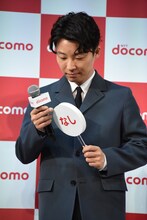 札の縁をなぞる星野源。