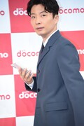 最新スマートフォンを持って登場する星野源。