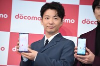 スマートフォンを丁寧に持つ星野源。