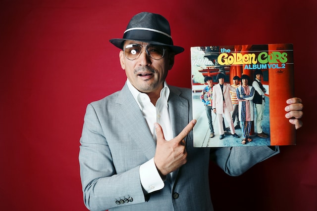 カップスに興味を持つきっかけになったという2ndアルバムを手にポーズを決める横山。