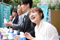 一般参加者へ参加特典のドリンクを手渡す高橋みなみ（手前）。