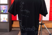 会場ロビーに置かれた出演者のサイン入りTシャツ。（Photo by Miki Azuma）