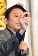 金のシャインマスカットを報道陣に見せる有吉弘行。