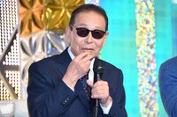 金のシャインマスカットを口に運ぶタモリ。