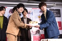 板垣瑞生（右）にバースデーケーキを手渡す吉田仁人（左）。