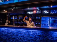 バーカウンターに入る佐藤店長。