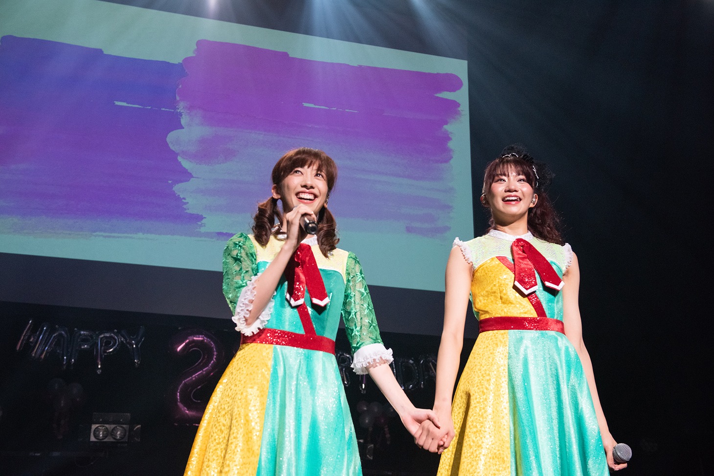 手をつないで歌う真山りか（左）と星名美怜（右）。