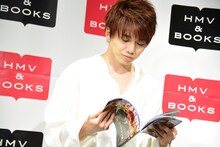 「あたりまえフォトブックin LAS VEGAS」よりお気に入りの「あたりまえポエム」が掲載されたページを探す花村想太。