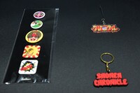 SHONEN CHRONICLE Badge（左）とSHONEN CHRONICLE Key Holder（右）。