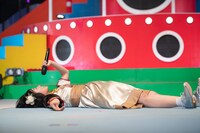 ステージ上に大の字になって寝そべる柏木ひなた。