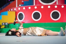 ステージ上に大の字になって寝そべる柏木ひなた。