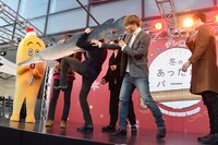 アリゲーターガーの実物大パネルを担ぐ八木勇征の筋肉事情を説明する瀬口黎弥（右から2番目）。