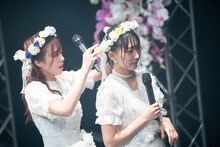 浦谷はるな（右）の花飾りを直す青木千春（左）。