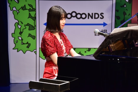 ピアノで「眼鏡の男の子」のメロディを弾く小林萌花。