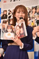 よく撮れたと思う写真（右）を挙げる秋元真夏。