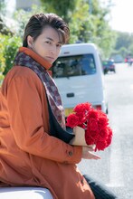 バラの花束を抱えたタカシ。