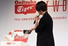 自身のスマートフォンでシューズを撮影する山下智久。