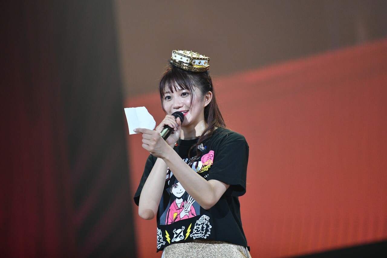 メモの切れ端に書いた舞台の情報をアナウンスする星名美怜。