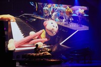 ベッドに座って電子ピアノを弾くまらしぃ。（Photo by Daisuke Ishizaka）