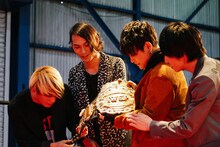 「IWGPヘビー級王座」のチャンピオンベルトを手にするTHE ORAL CIGARETTES。