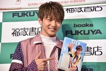 「STEP BY STEP」を指差す佐藤大樹。