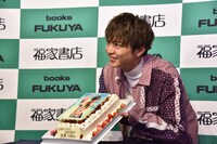 「STEP BY STEP」表紙がデザインされたバースデーケーキと佐藤大樹。