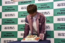 バースデーケーキをまじまじと見る佐藤大樹。