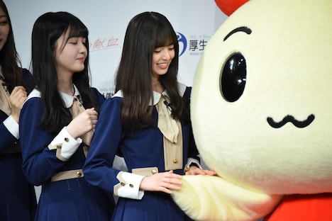 けんけつちゃんの手に触れる齋藤飛鳥。