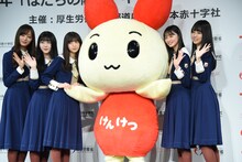 記念撮影の際にけんけつちゃんの手を握る齋藤飛鳥。