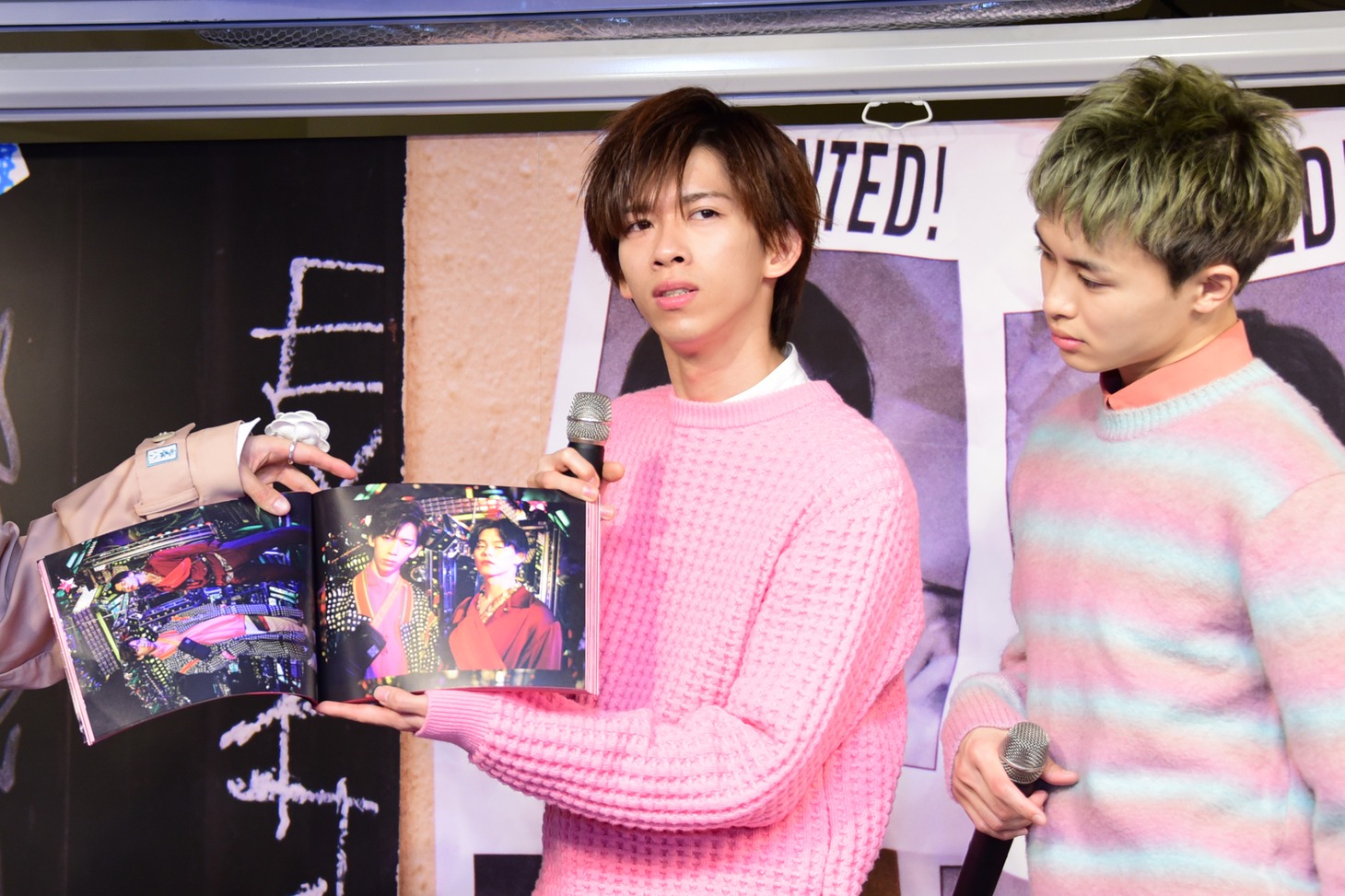 カイのお気に入りカットを持つリョウガ（左）と、それを見るタクヤ（右）。