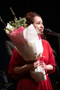 花束を抱えたまま歌う脇田もなり。