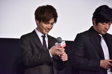 マイクのスイッチを確認する岩田剛典。