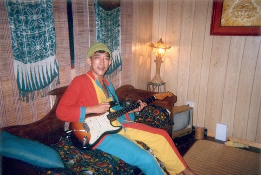 お気に入りのパジャマを着て自宅でギター片手にくつろぐどんと。