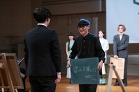 とーやま校長に黒板を渡す山口一郎。