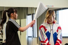 セントチヒロ・チッチ（BiSH）をハリセンで叩くア・アンズピア（WAgg）。