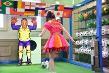 アーケードゲームコーナーでサッカーのゲームに挑戦する坂井仁香。