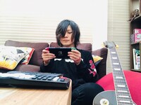 ギターを傍らに置き、Nintendo Switchで「UNO」を嗜むこやまたくや（G, Vo）。