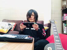 ギターを傍らに置き、Nintendo Switchで「UNO」を嗜むこやまたくや（G, Vo）。