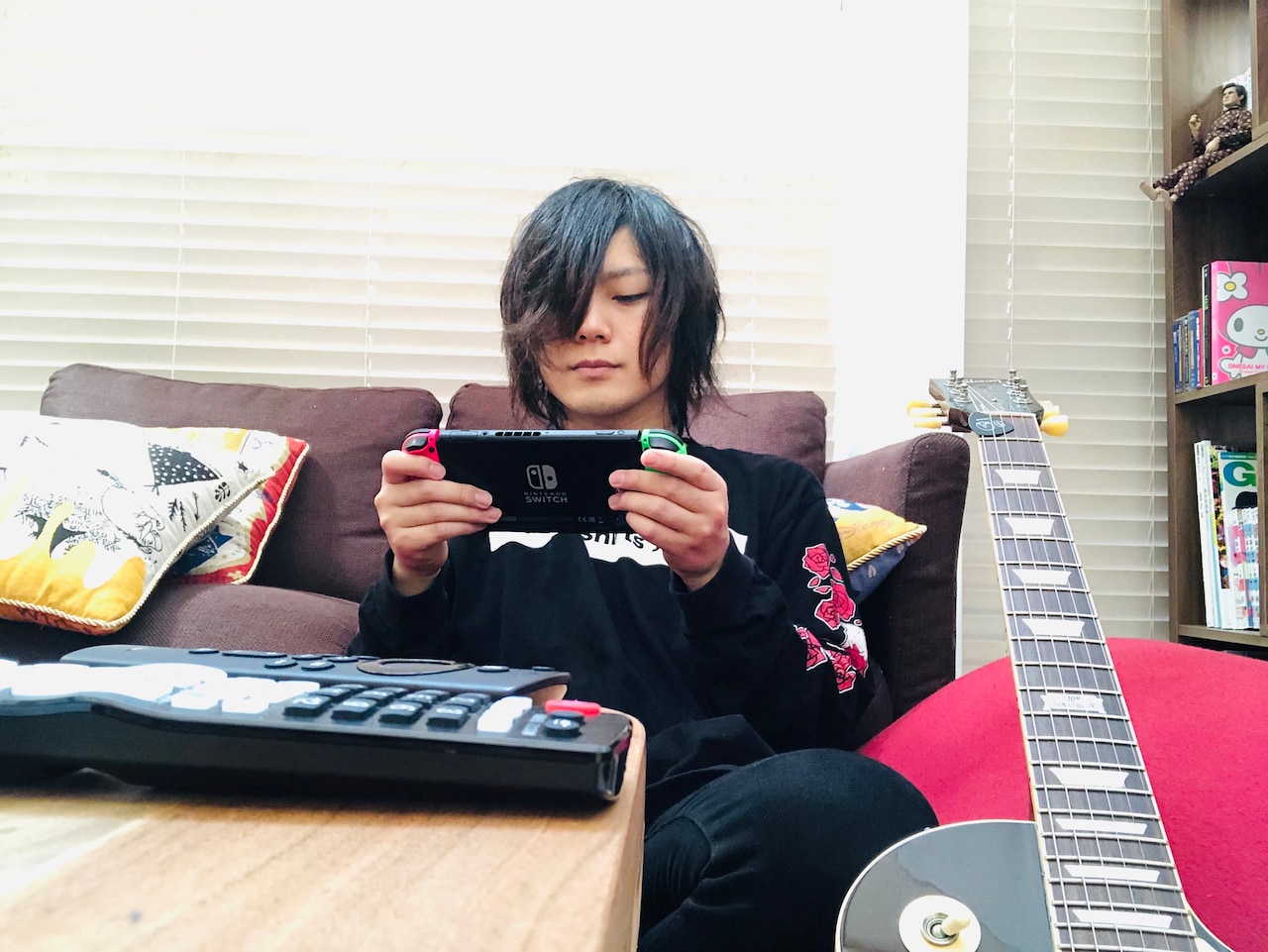 ギターを傍らに置き、Nintendo Switchで「UNO」を嗜むこやまたくや(G, Vo)。