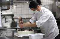 厨房でケーキに文字を入れるKREVA。（Photo by curly_mads）