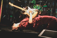 ブリッジをしながらギターソロを弾く石毛輝（Vo, G, Syn）。（Photo by Takahiro Takinami）