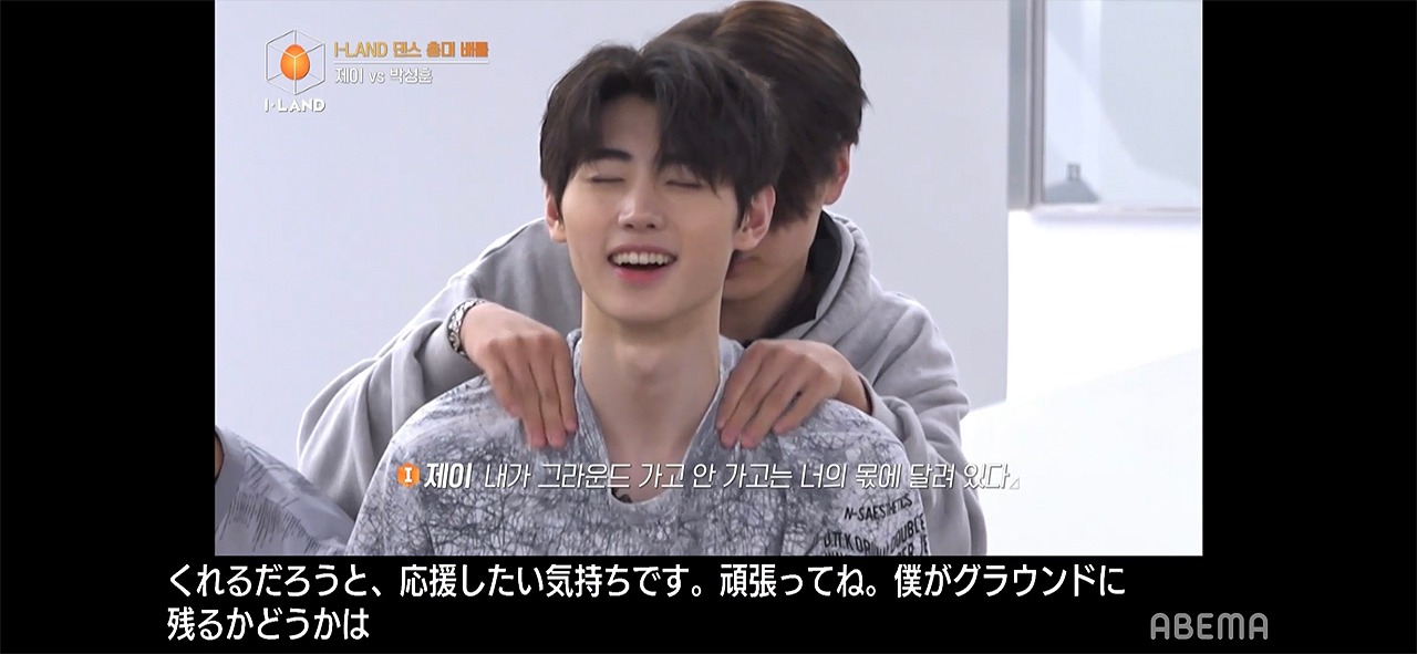 自分に代わってステージに立つことになったソンフン（前）をねぎらうジェイ（後ろ）。(c)AbemaTV,Inc.
