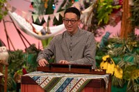 大正琴煮挑戦するMCの高橋茂雄（サバンナ）。（写真提供：NHK）