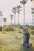 千葉・館山にて。海沿いにある灯台とヤシの木と彫刻。