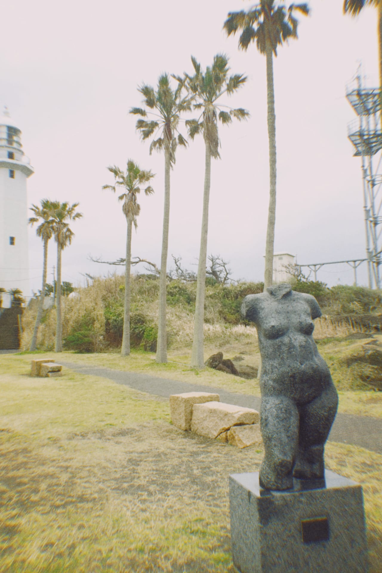 千葉・館山にて。海沿いにある灯台とヤシの木と彫刻。