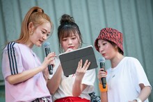 生配信に寄せられたコメントをチェックするminan、hinako、risano（左から）。