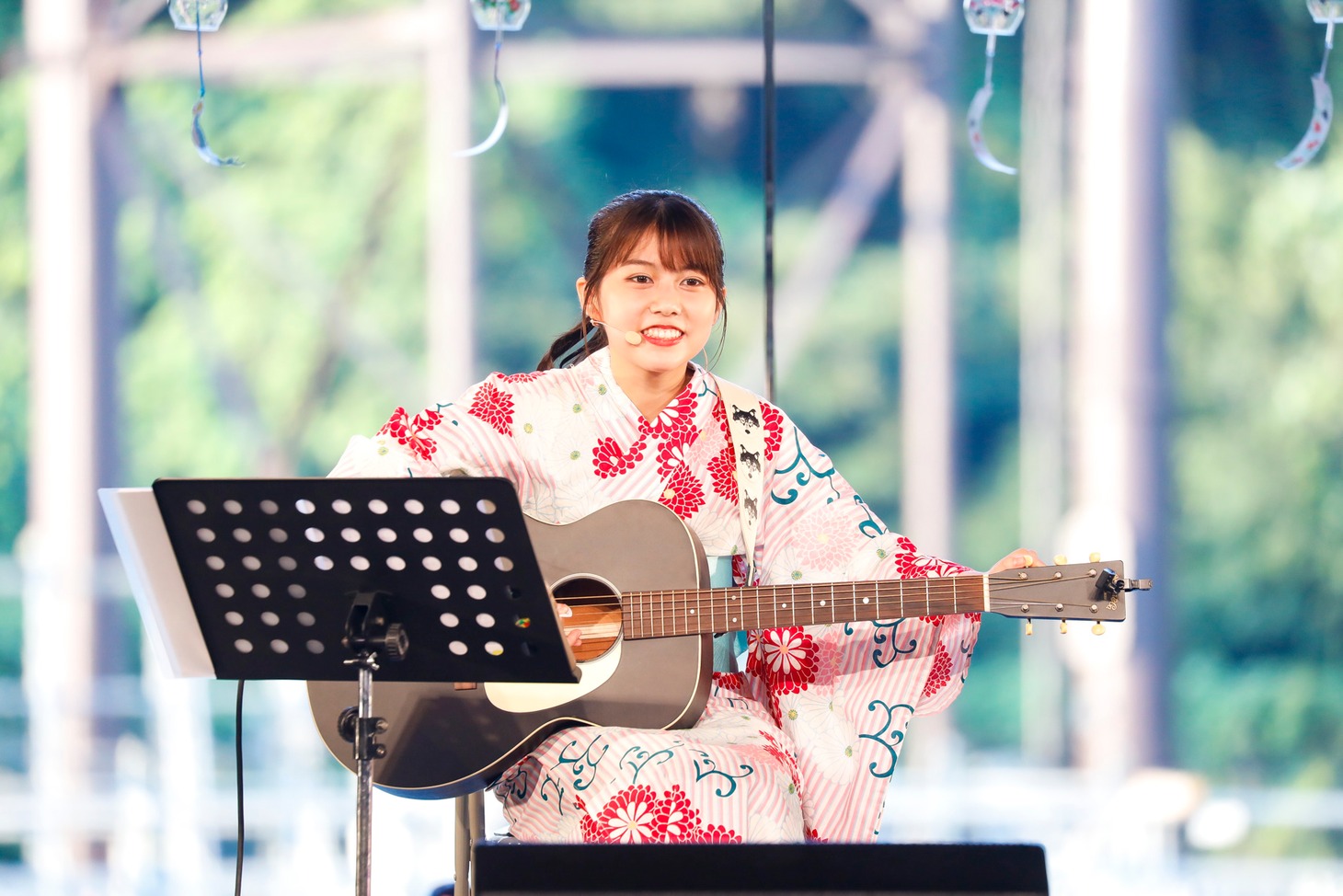 アコースティックギターで弾き語りする鈴木萌花。（写真提供：スターダストプロモーション）