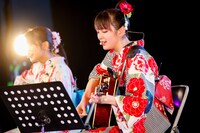 アコースティックギターで弾き語りする鈴木萌花と愛来。（写真提供：スターダストプロモーション）