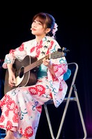 アコースティックギターで弾き語りする鈴木萌花。（写真提供：スターダストプロモーション）